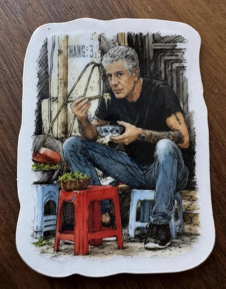 This is my happy place. Anthony Bourdain eating noodles on a small stool in Vietnam. Small, clear laptop sticker.